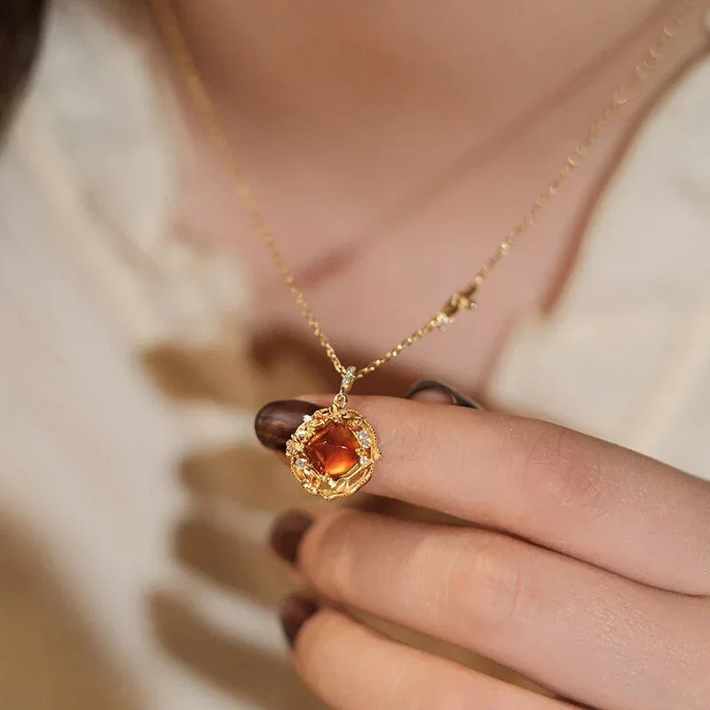 Round Garnet Vintage Drop Necklace worn at the neckline in a close-up