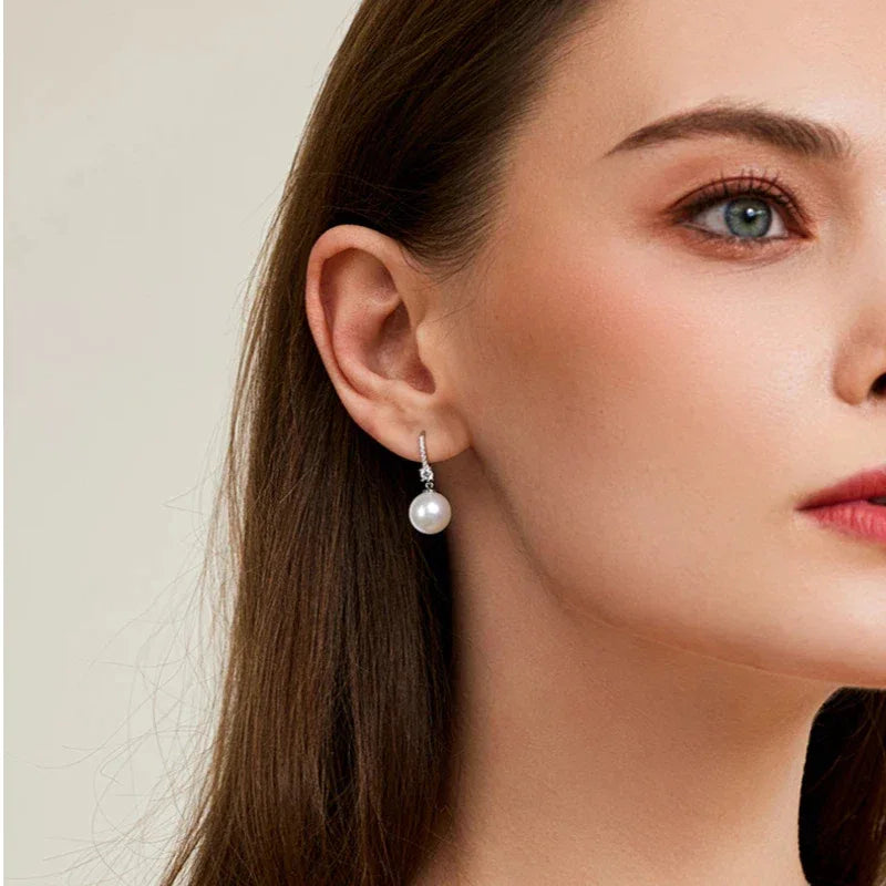 Pearl Drop Earrings with Floral Connector — left-ear worn portrait showing scale