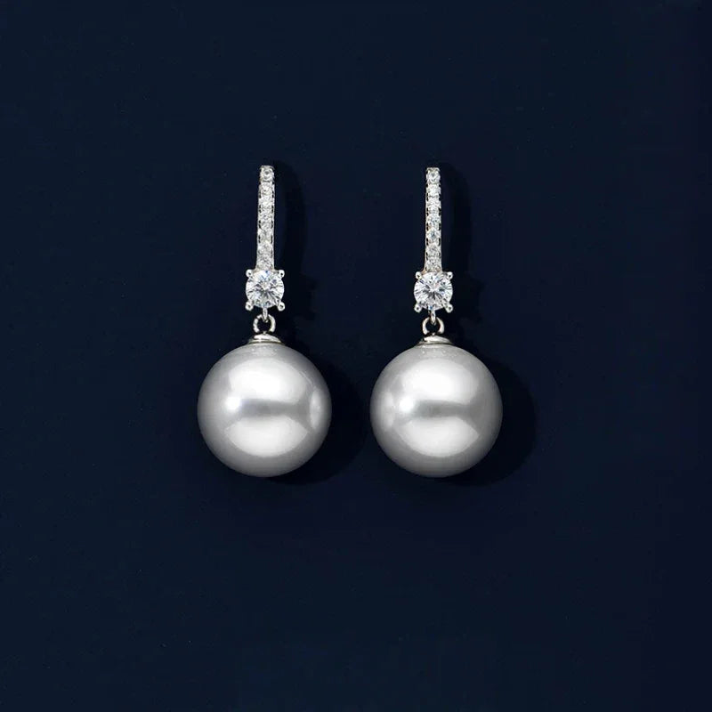 Pearl Drop Earrings with Floral Connector — pair displayed on a dark background