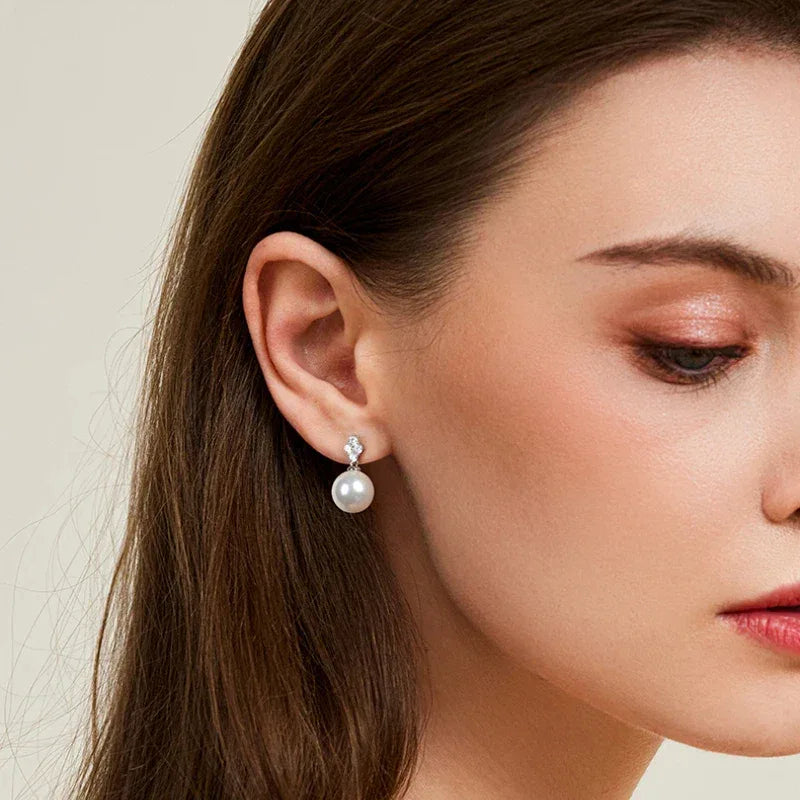 Pearl Teardrop Stud Earrings — left-ear worn portrait with the face angled downward