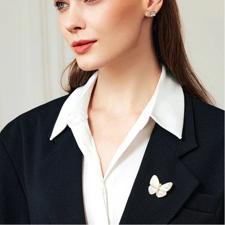 White Pearl Butterfly Brooch — waist-up model portrait with the brooch on a dark blazer