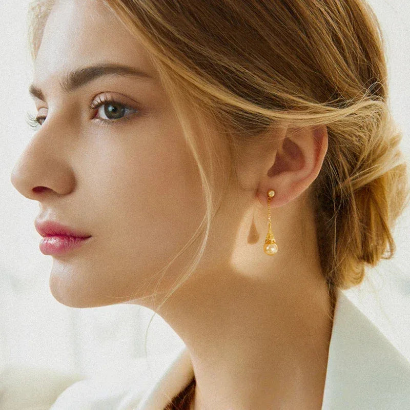 Shell Pearl Eiffel Tower Drop Earrings — gold-tone earrings worn in a side-profile portrait