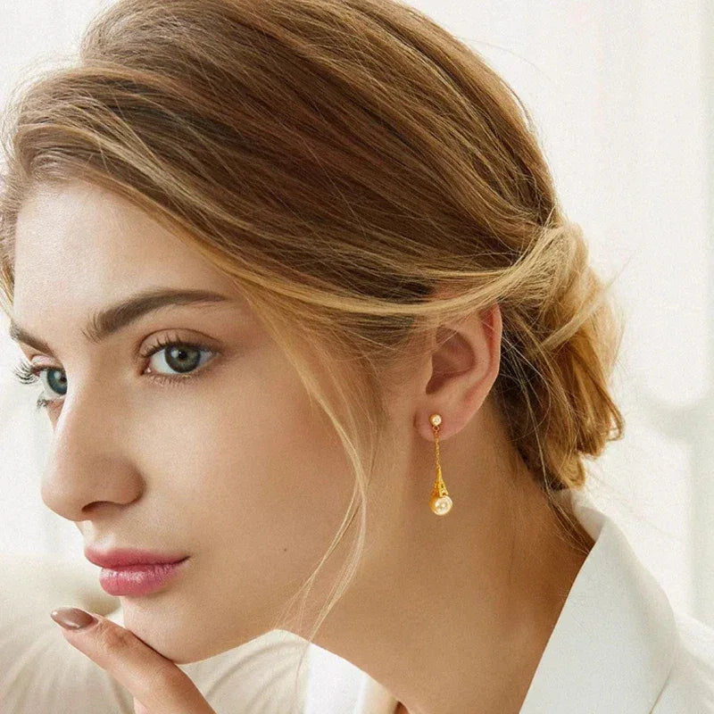 Shell Pearl Eiffel Tower Drop Earrings — alternate gold-tone worn view from a slightly wider angle
