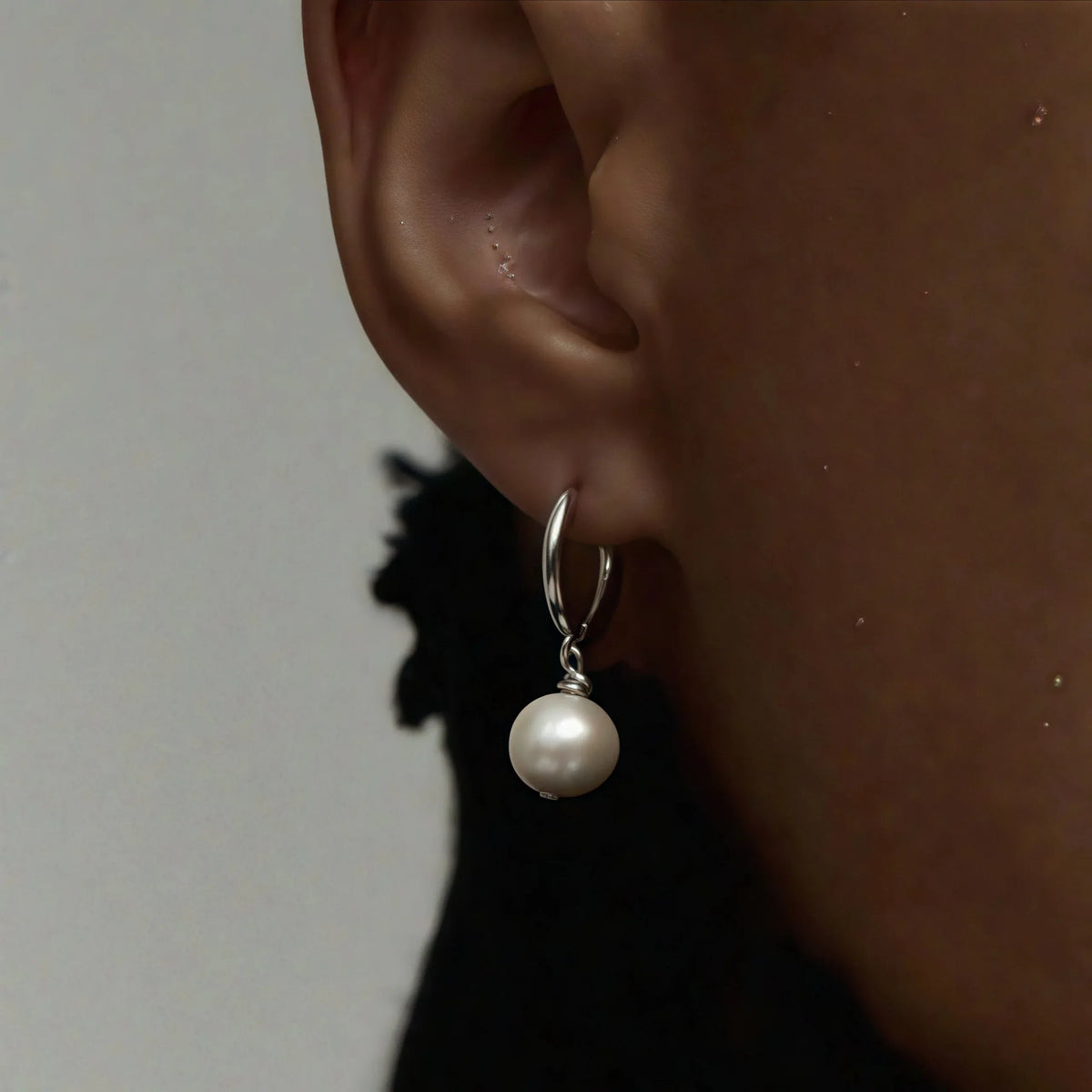 Double-Pearl Drop Hoop Earrings — close right-ear worn view showing the hoop and pearl spacing