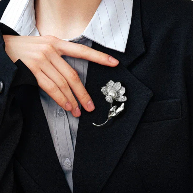 Malachite Flower Brooch — waist-up blazer-worn portrait beside the model's hand