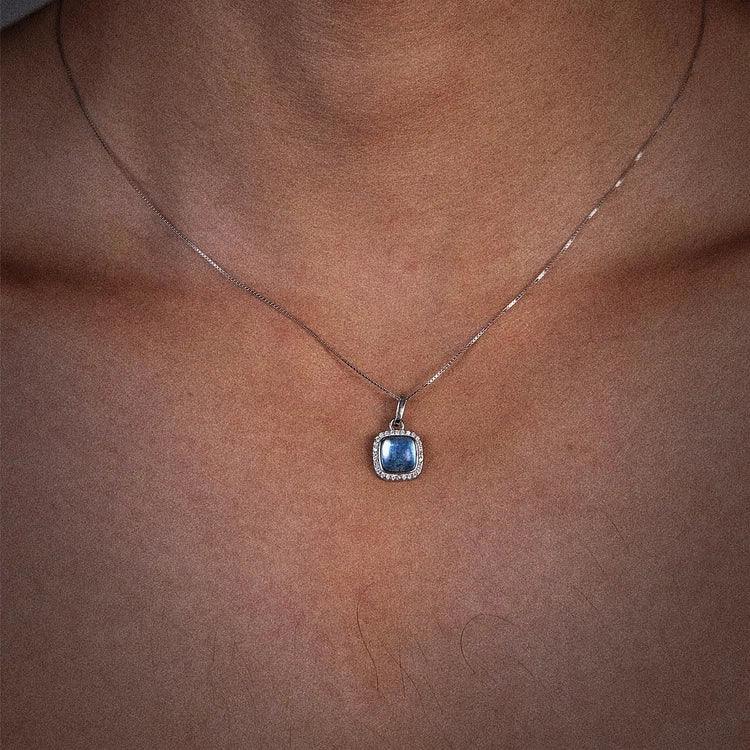 Square Aquamarine Halo Pendant Necklace worn at the neckline in a close-up