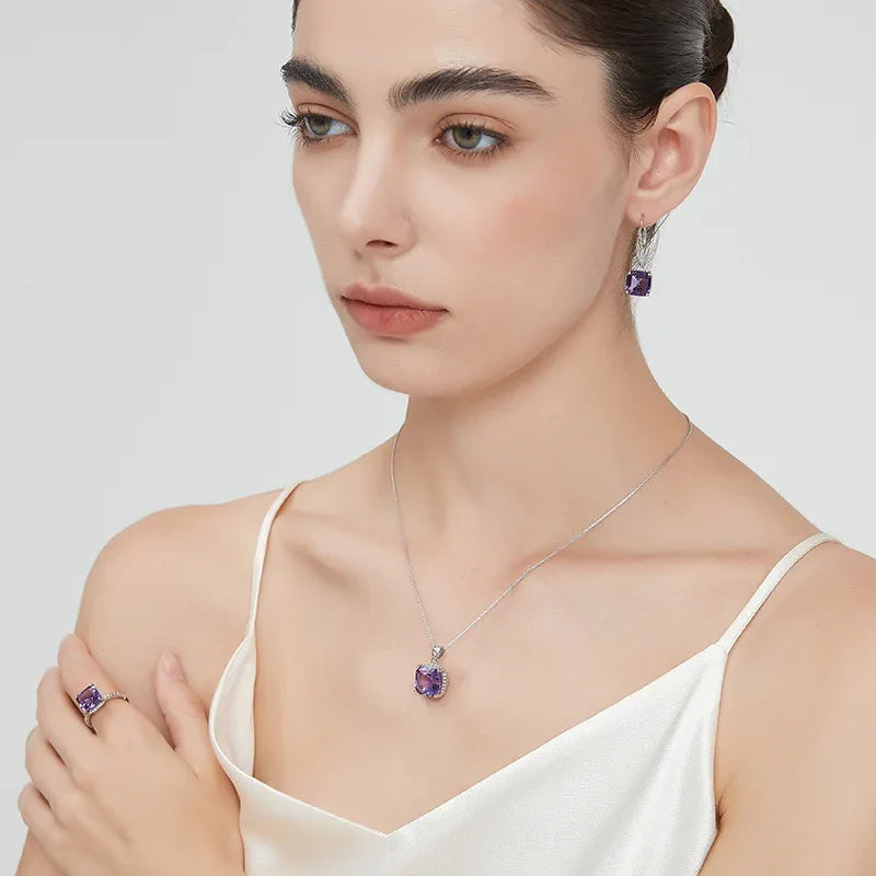 square-cut amethyst drop earrings worn on the ear in a close-up