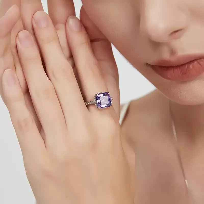 square-cut amethyst halo ring worn on the hand in a close-up