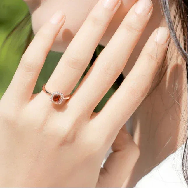 Square-Cut Garnet Halo Ring side view held between the fingers