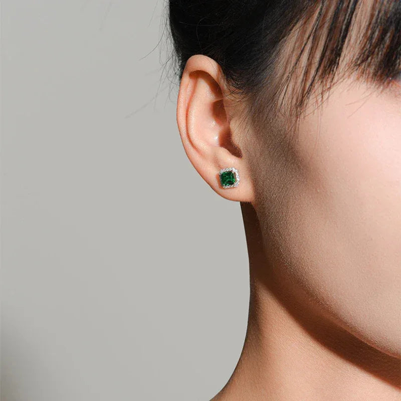 Square Emerald Halo Stud Earrings worn on the ear from a second angle