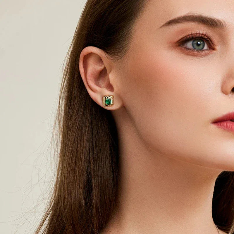 Square Emerald Layered Stud Earrings worn on the ear in a close-up