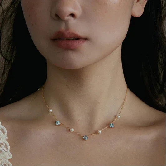 Blue Topaz and Pearl Floral Station Necklace — closer neckline-worn portrait showing the center station