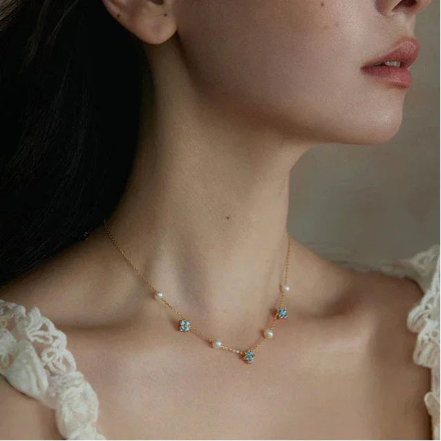 Blue Topaz and Pearl Floral Station Necklace — side-profile neckline-worn view