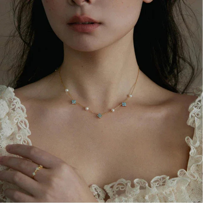 Blue Topaz and Pearl Floral Station Necklace — front neckline-worn portrait over a lace-trim top