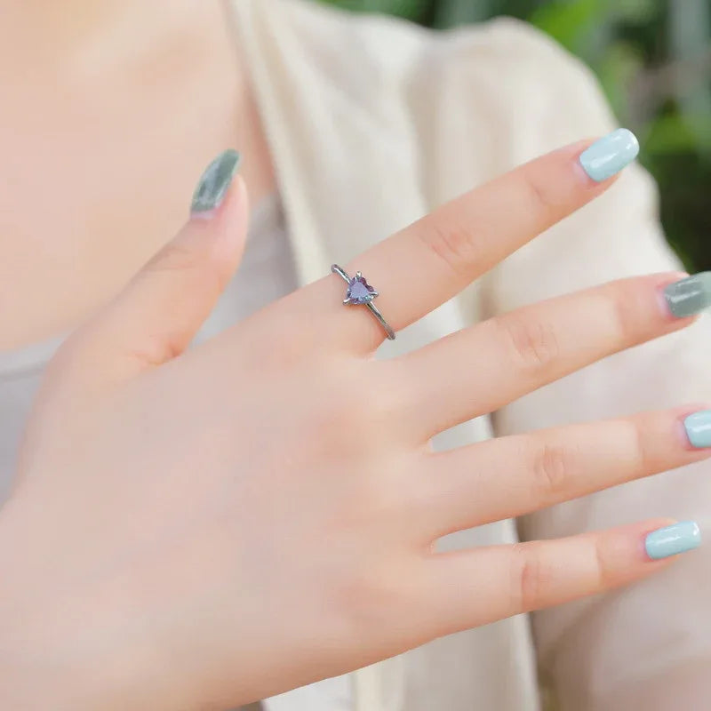 Trillion-cut Alexandrite solitaire ring, shown worn in a close lifestyle view