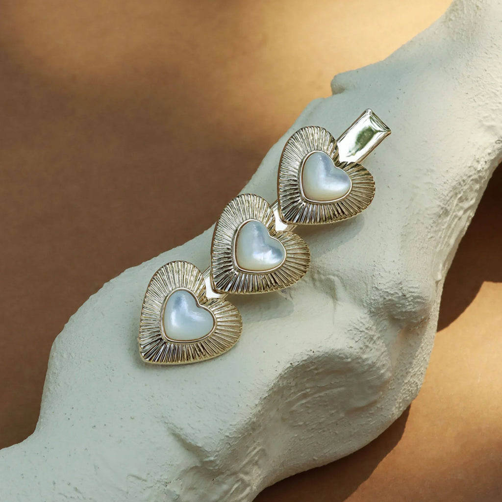 Triple Pearl Heart Hair Clip — clip displayed on a pale textured surface
