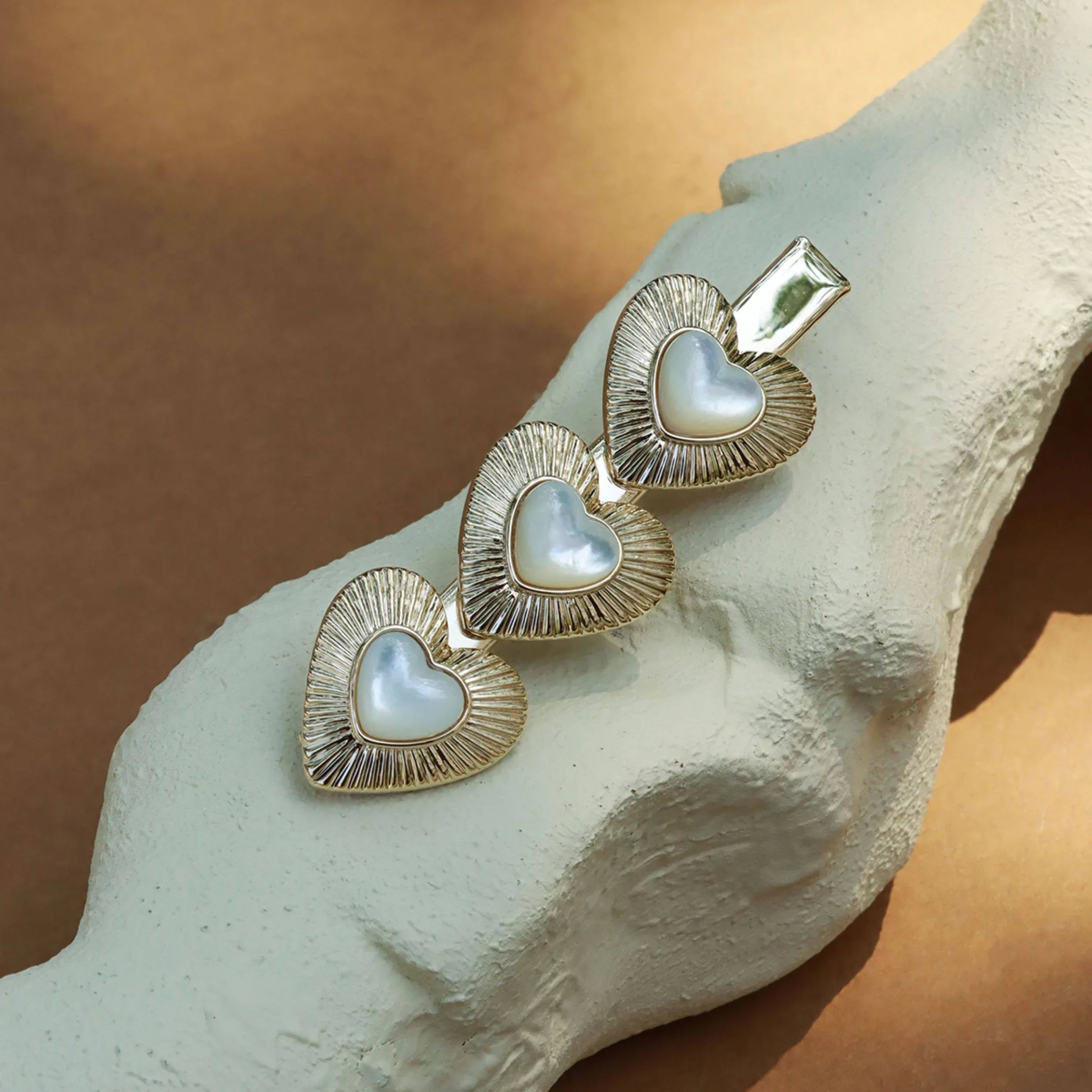 Triple Pearl Heart Hair Clip — clip displayed on a pale textured surface