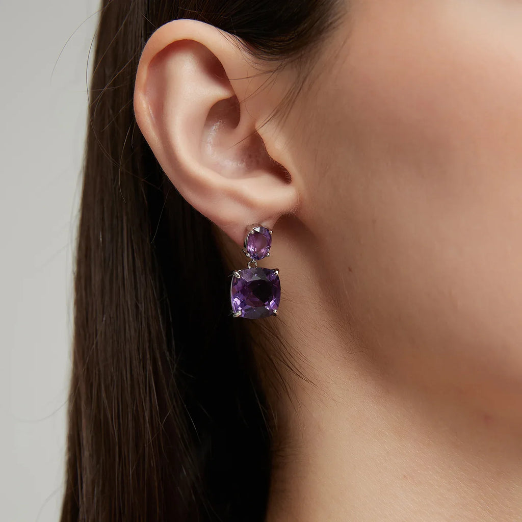 two-stone amethyst drop earrings worn on the ear in a close-up