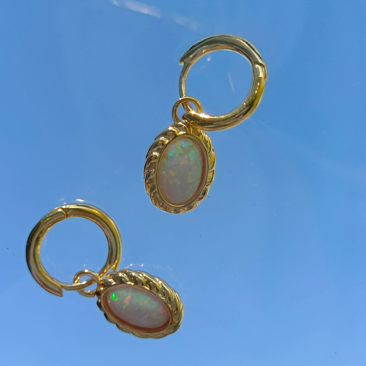 White Opal Oval Hoop Drop Earrings worn on the hand