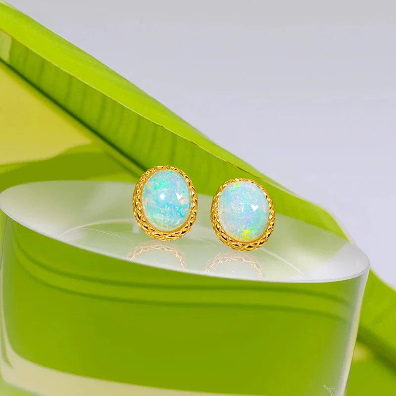 White Opal Oval Stud Earrings worn on the hand